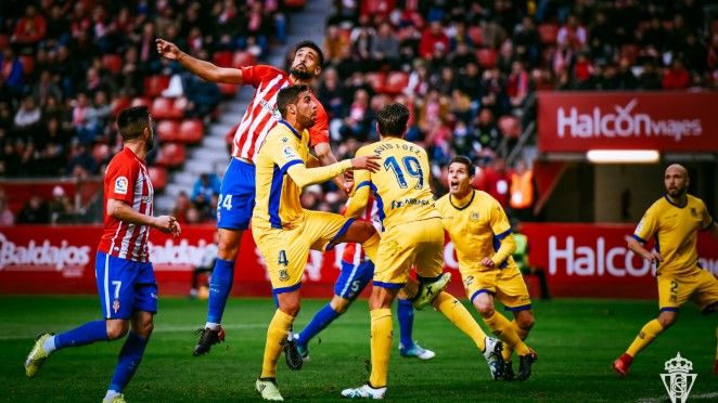 Álex Pérez luchando un balón por alto con la defensa del Alcorcón