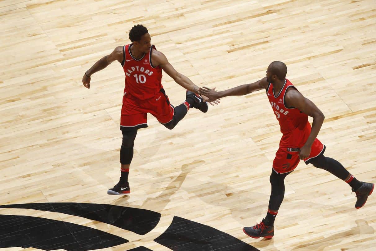 DeMar DeRozan y Serge Ibaka chocan las manos celebrando una acción del partido ante los Celtics. (Photo by Mark Blinch/NBAE via Getty Images)