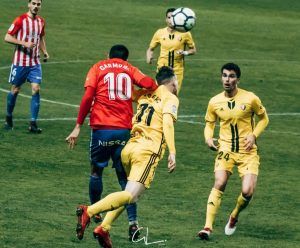 Carmona y Clerc disputan un balón en el Sporting - Osasuna del pasado viernes