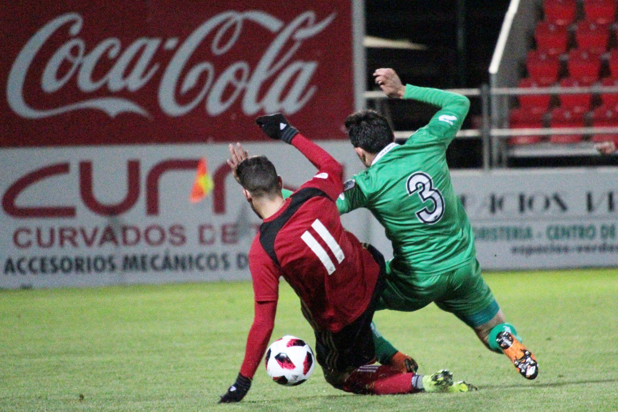 Álvaro Rey (Mirandés) pugna con un balón con Ricard (Cornellà). Foto: Paula González