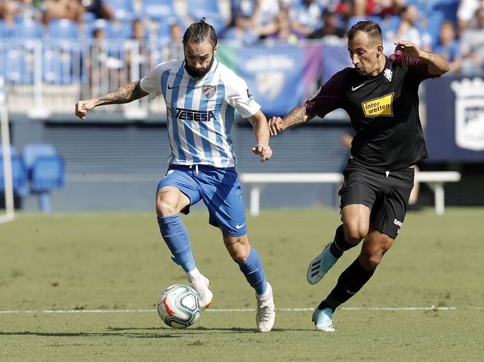 Cifuentes conduce un balón ante Aitor García en un Málaga - Sporting la pasada campaña