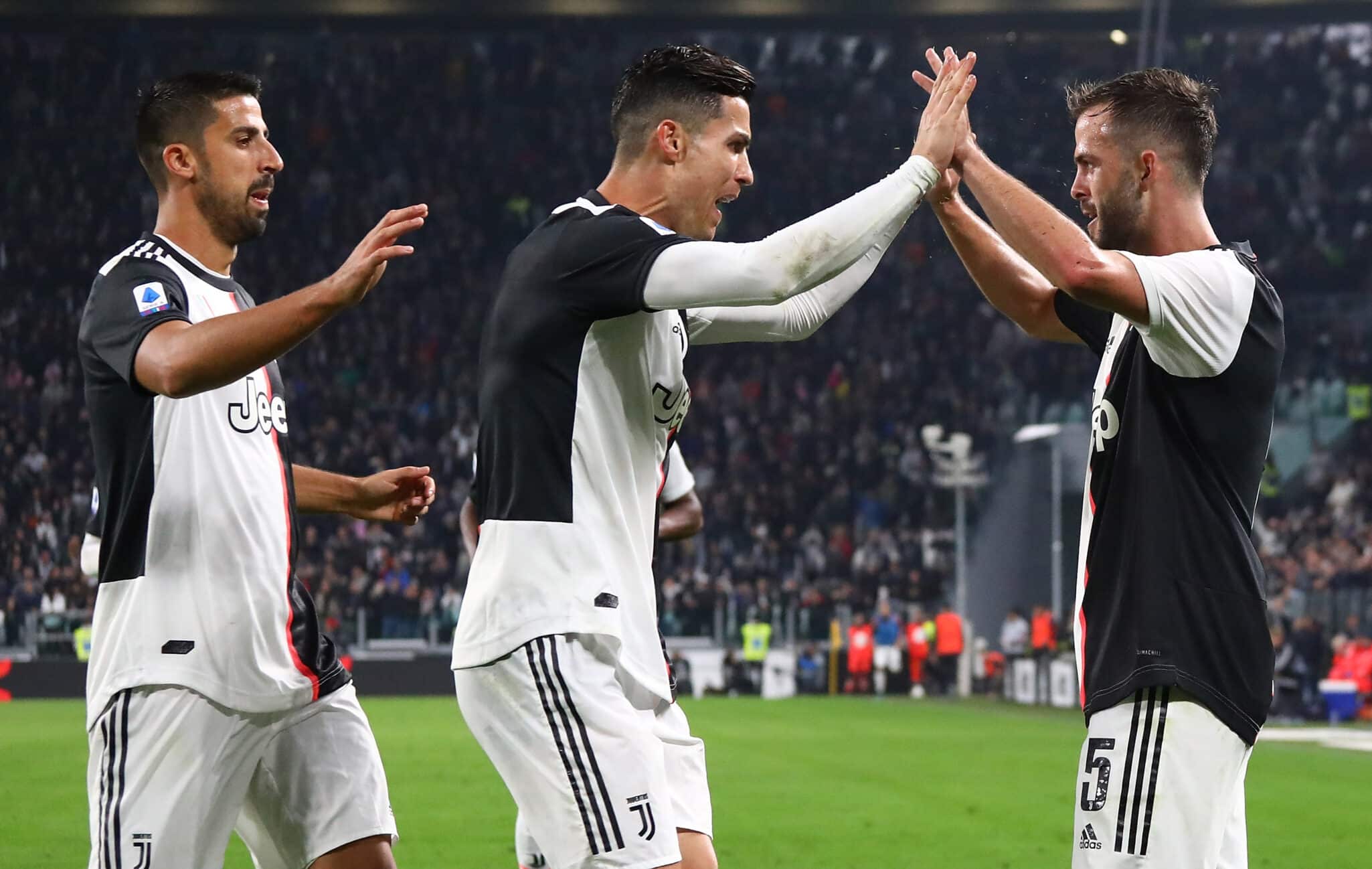 TURIN, ITALY - OCTOBER 19: Miralem Pjanic (R) of Juventus celebrates his goal with his team-mates Sami Khedira (L) and Cristiano Ronaldo (C) during the Serie A match between Juventus and Bologna FC at Allianz Stadium on October 19, 2019 in Turin, Italy. (Photo by Marco Luzzani/Getty Images)
