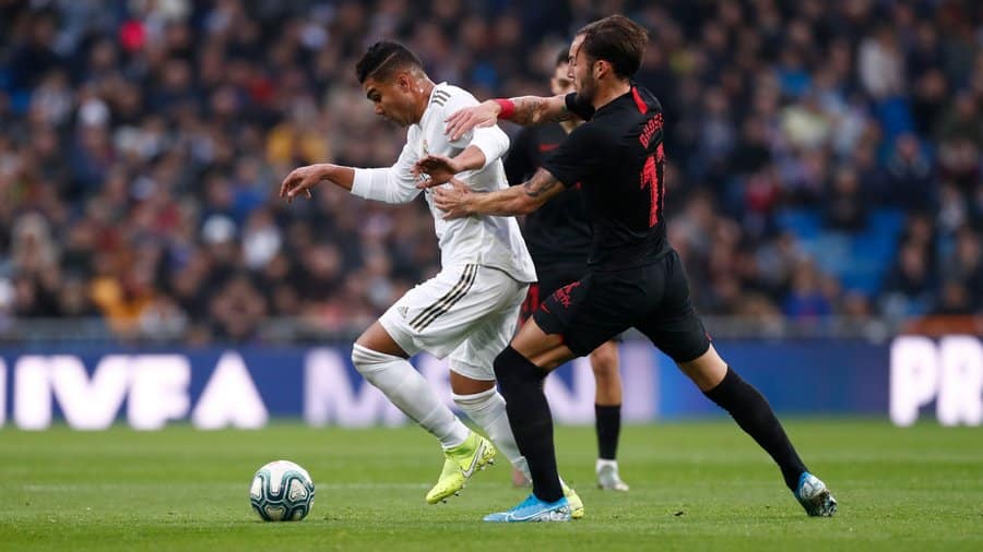 Casemiro protege un balón ante Gudelj en un Real Madrid Club de Fútbol - Sevilla Fútbol Club. Foto: Real Madrid Club de Fútbol.