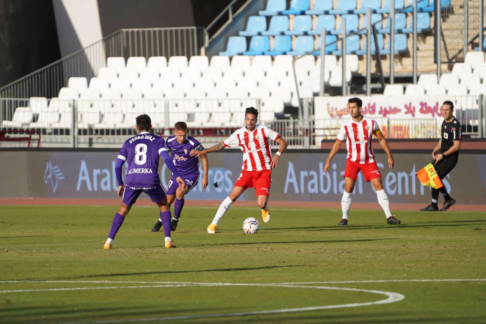 Centelles conduce el esférico ante la mirada de Cumic y Pedro Díaz en el Almeriá - Sporting