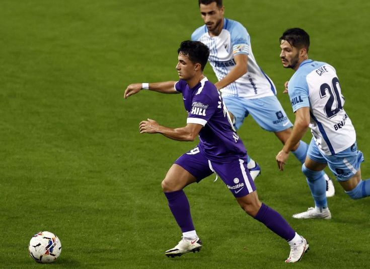 Manu García conduce el balón en un Málaga - Sporting