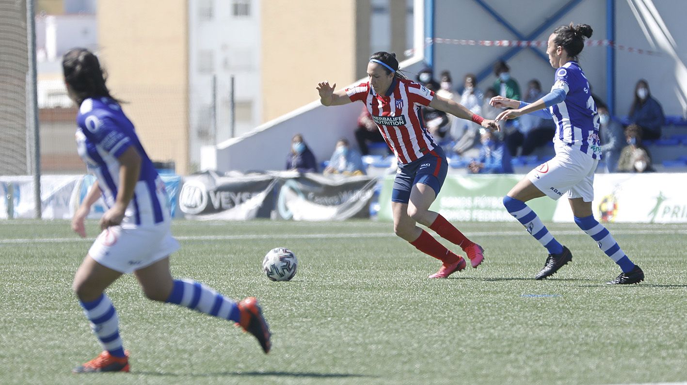 Silvia Meseguer controla el balón frente a dos jugadoras del equipo onubense