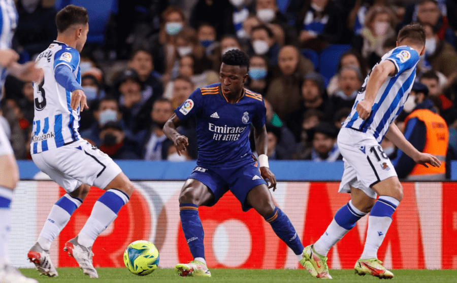 Vinícius Júnior, rodeado por Martín Zubimendi y Andoni Gorosabel en un Real Sociedad de Fútbol - Real Madrid Club de Fútbol