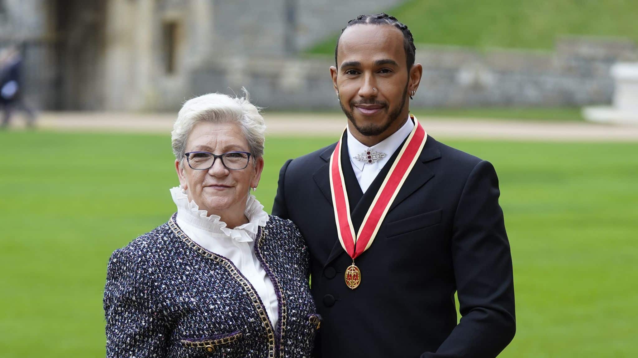 Sir Lewis Hamilton junto con su madre, en la ceremonia de investidura como caballero del imperio británico. Imagen: @RoyalFamily