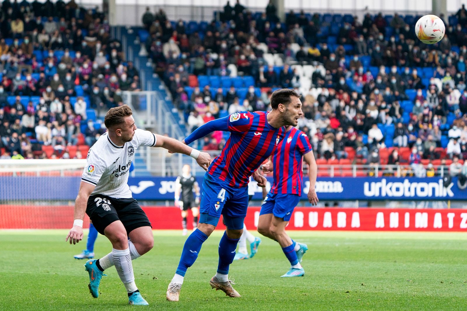 Rober Correa despeja un balón ante la oposición de Ontiveros en un Eibar-Fuenlabrada