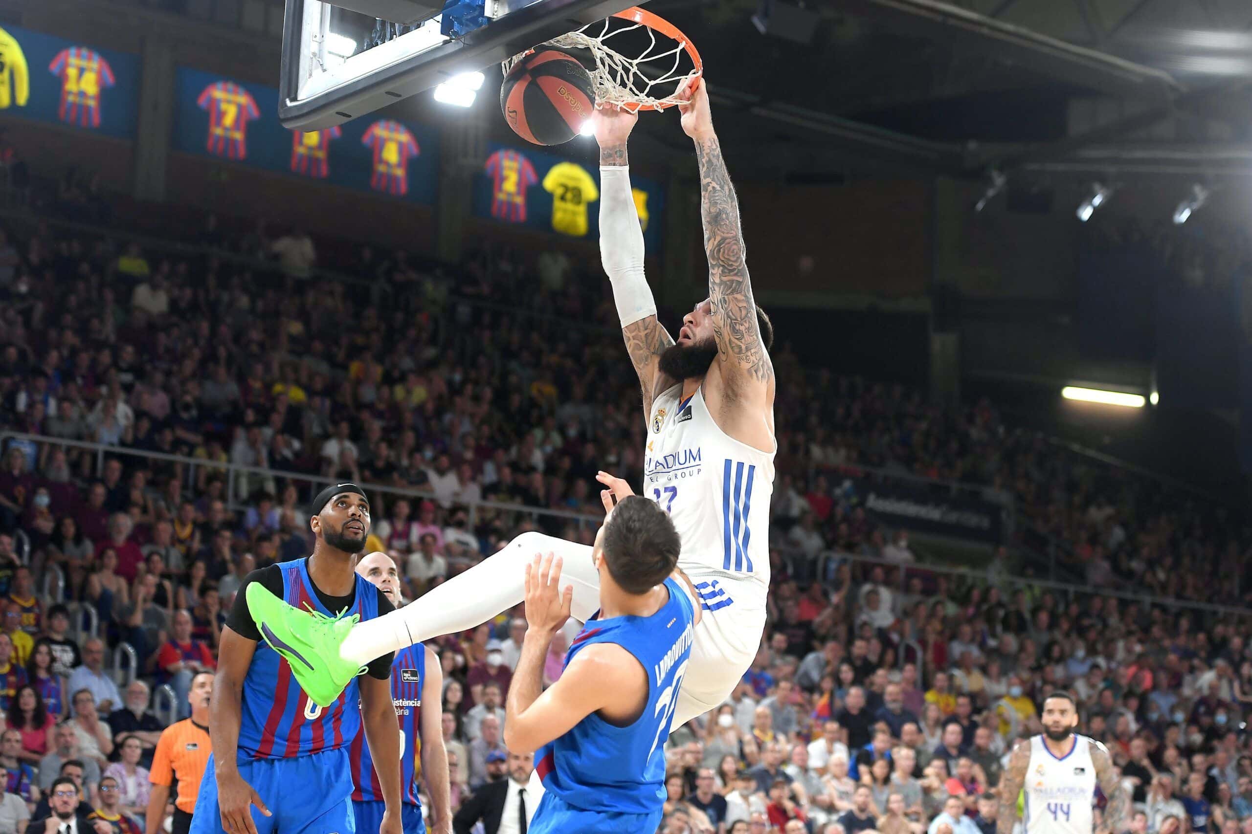 Vincent Porier se cuelga del aro ante la mirada de Brandon Davies y Nico Laprovittola. Foto: @ACBCOM