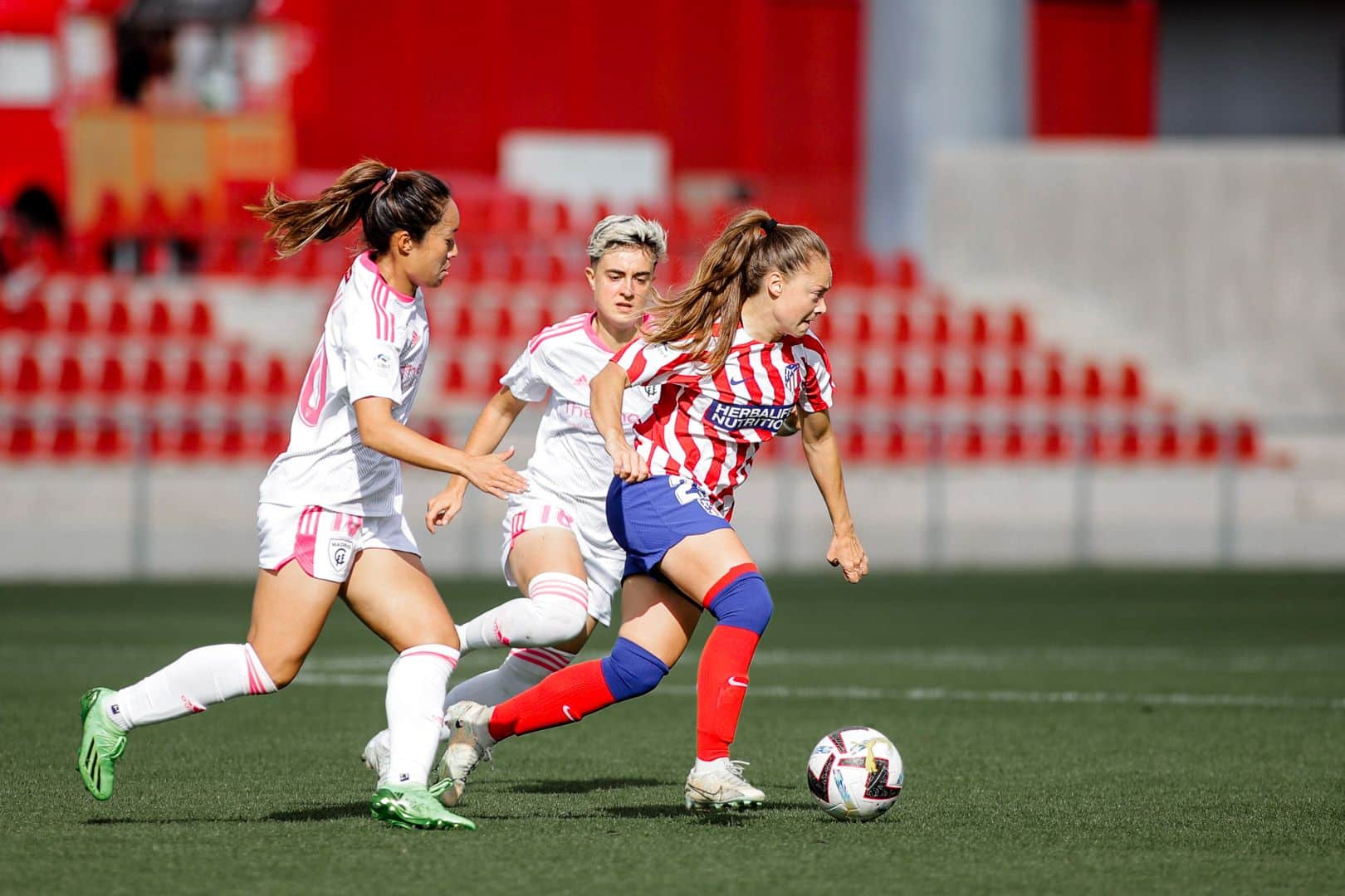 Banini ante Tang (izquierda) y Lucía Pardo. Fuente: Twitter Oficial del Atlético de Madrid (@AtletiFemenino)