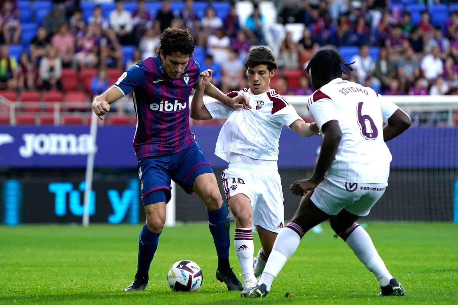 Blanco Leschuk pugna un balón con Riki Rodríguez y Boyomo