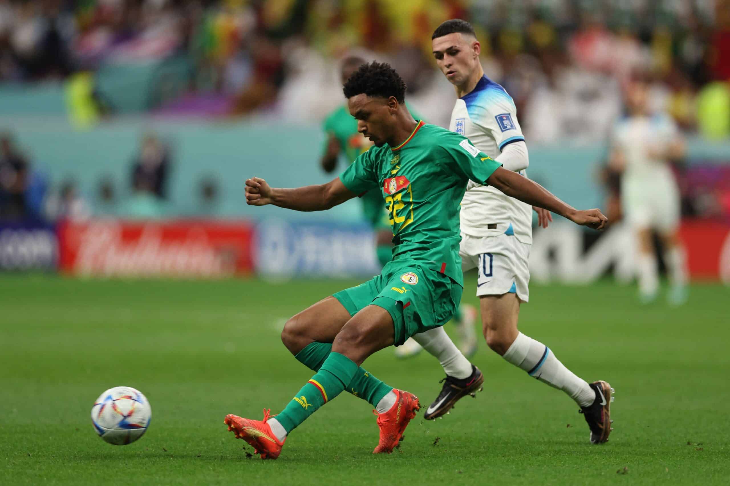 Senegal's defender #22 Abdou Diallo (L) fights for the ball with England's forward #20 Phil Foden during the Qatar 2022 World Cup round of 16 football match between England and Senegal at the Al-Bayt Stadium in Al Khor, north of Doha on December 4, 2022. (Photo by Adrian DENNIS / AFP) (Photo by ADRIAN DENNIS/AFP via Getty Images)