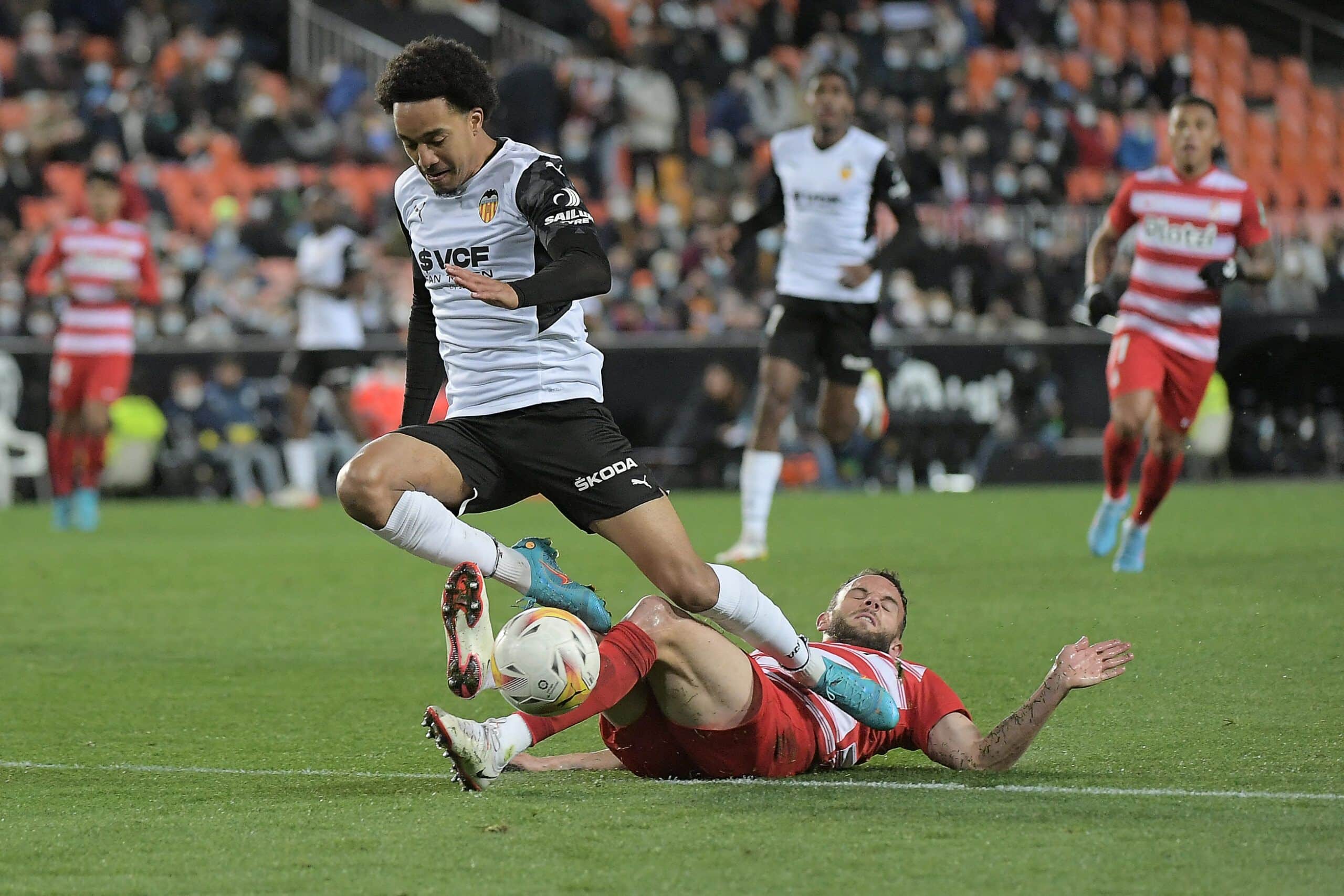Valencia's Angolan midfielder Helder Costa (L) fights for the ball with Granada's Spanish defender Quini during the Spanish league football match between Valencia CF and Granada FC at the Mestalla stadium in Valencia on March 5, 2022. (Photo by Jose Jordan / AFP) (Photo by JOSE JORDAN/AFP via Getty Images)