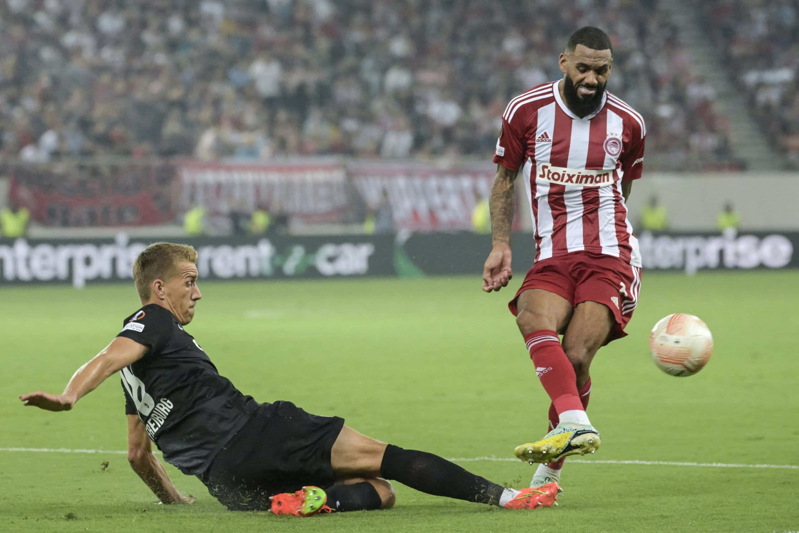 Freiburg's German forward Nils Petersen (L) tackles Olympiacos French midfielder Yann M'Vila (R) during the UEFA Europa League Group G football match between Olympiacos FC (GRE) and SC Freiburg (GER) at the Karaisms Stadium in Athens on September 15, 2022. (Photo by ARIS MESSINIS / AFP) (Photo by ARIS MESSINIS/AFP via Getty Images)