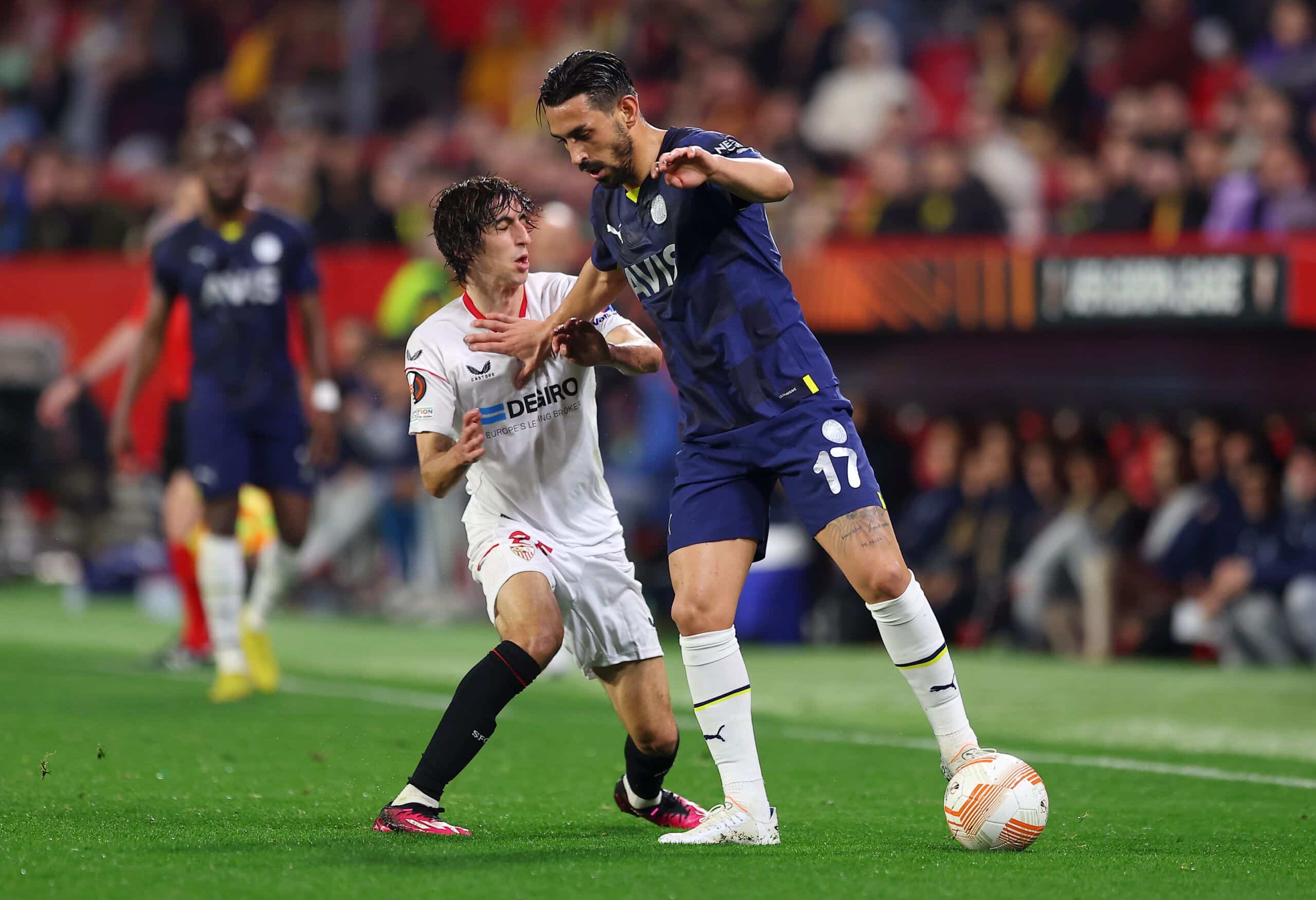 SEVILLE, SPAIN - MARCH 09: Bryan Gil of Sevilla FC battles for possession with Irfan Can Kahveci of Fenerbahce during the UEFA Europa League round of 16 leg one match between Sevilla FC and Fenerbahce at Estadio Ramon Sanchez Pizjuan on March 09, 2023 in Seville, Spain. (Photo by Fran Santiago/Getty Images)