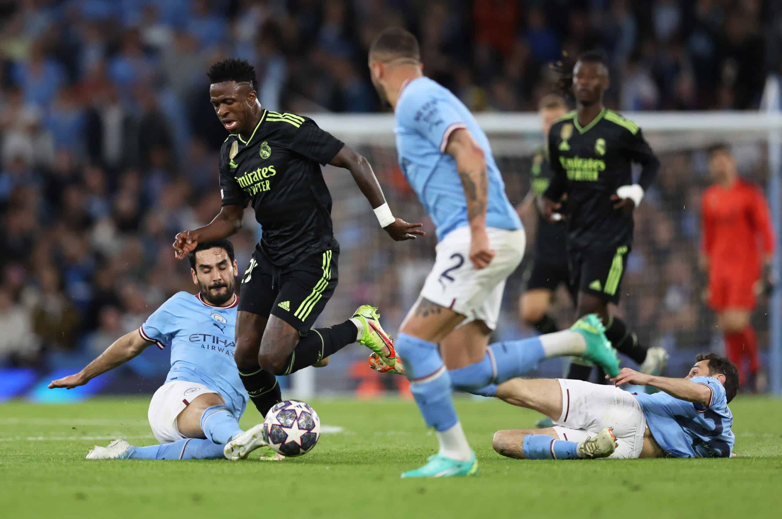 MANCHESTER, ENGLAND - MAY 17: Vinicius Junior of Real Madrid is challenged by Ilkay Guendogan of Manchester City during the UEFA Champions League semi-final second leg match between Manchester City FC and Real Madrid at Etihad Stadium on May 17, 2023 in Manchester, England. (Photo by Clive Brunskill/Getty Images)