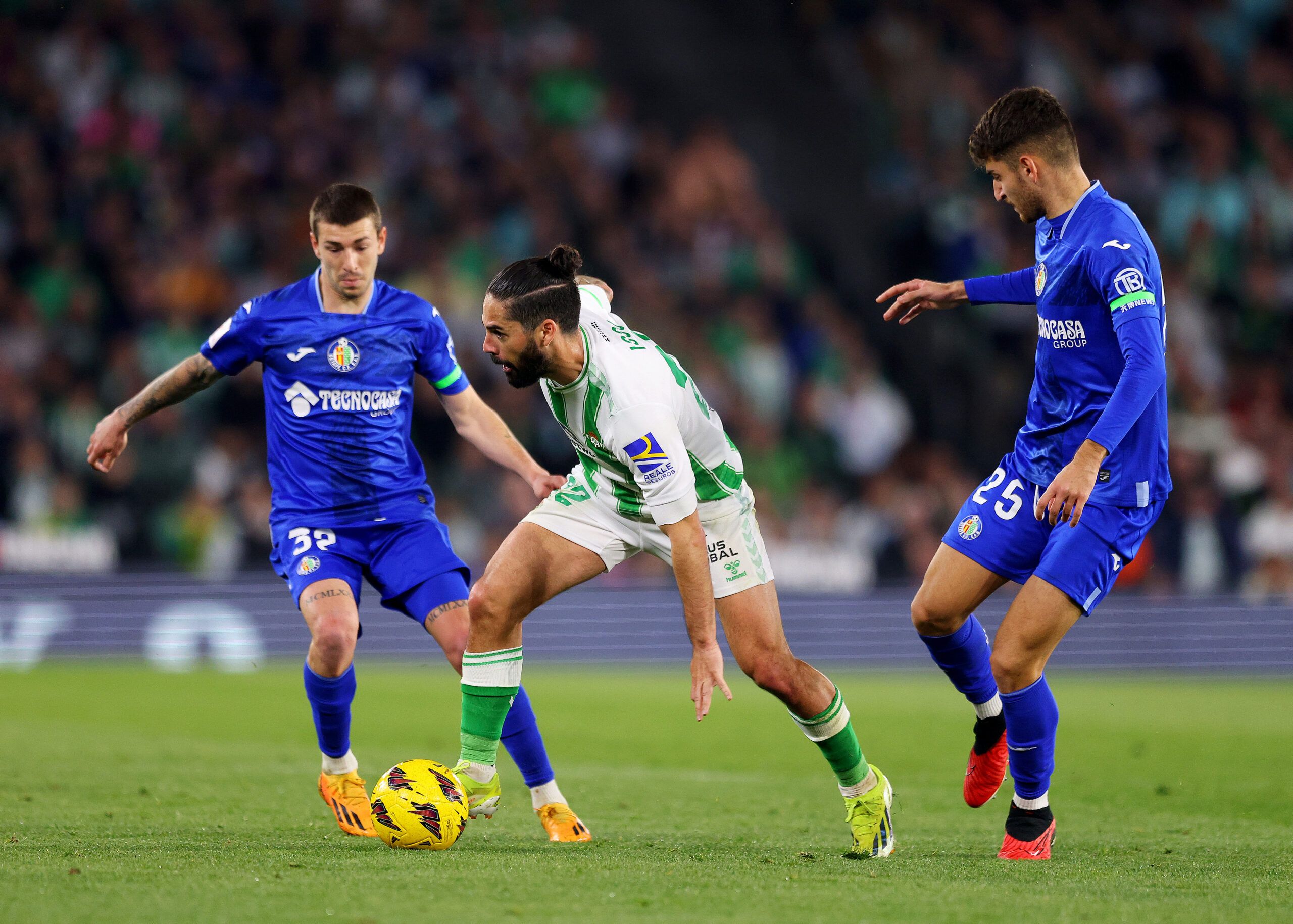 SEVILLE, SPAIN - FEBRUARY 04: Isco of Real Betis on the ball whilst under pressure from Yellu Santiago and Jordi Martin of Getafe CF during the LaLiga EA Sports match between Real Betis and Getafe CF at Estadio Benito Villamarin on February 04, 2024 in Seville, Spain. (Photo by Fran Santiago/Getty Images)