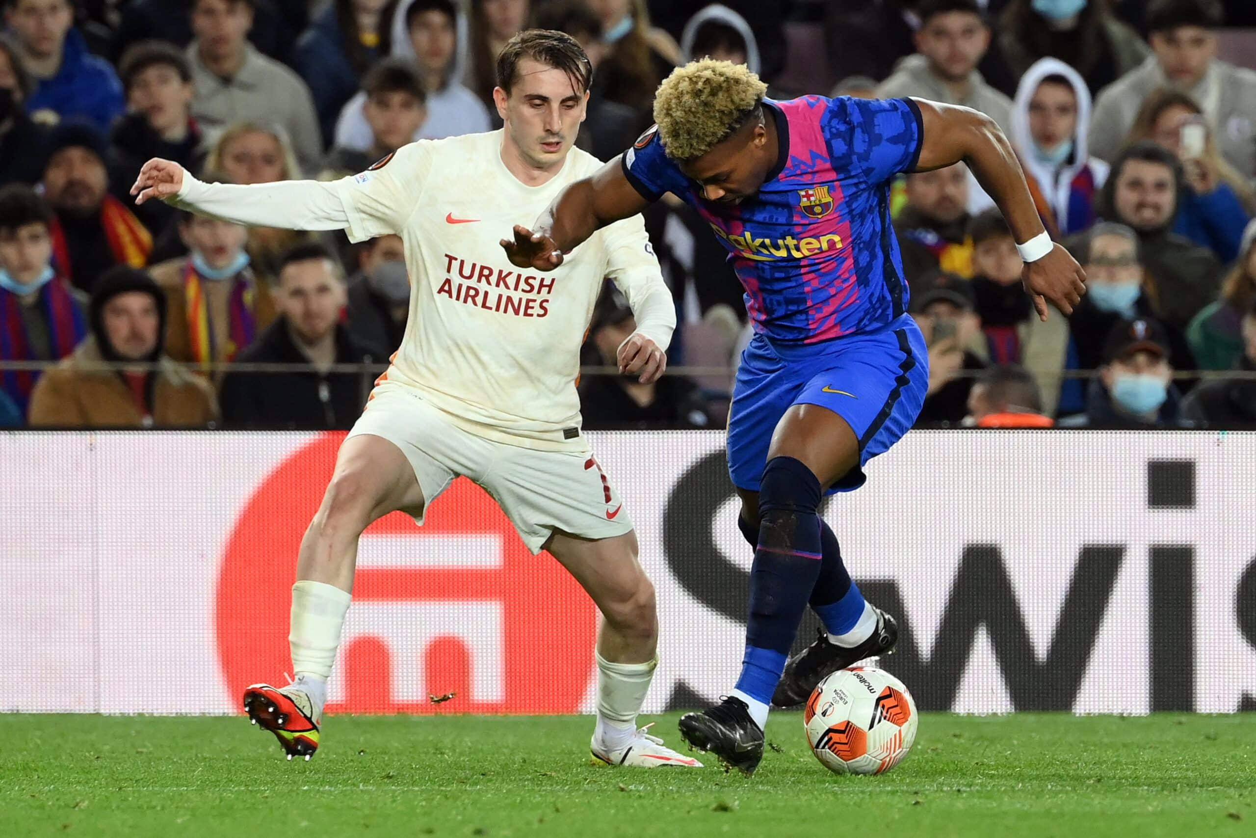 Galatasaray's Turkish forward Kerem Aktürkoglu (L) challenges Barcelona's Spanish forward Adama Traore during the UEFA Europa League round of 16 first leg football match between FC Barcelona and Galatasaray at the Camp Nou stadium in Barcelona on March 10, 2022. (Photo by LLUIS GENE / AFP) (Photo by LLUIS GENE/AFP via Getty Images)