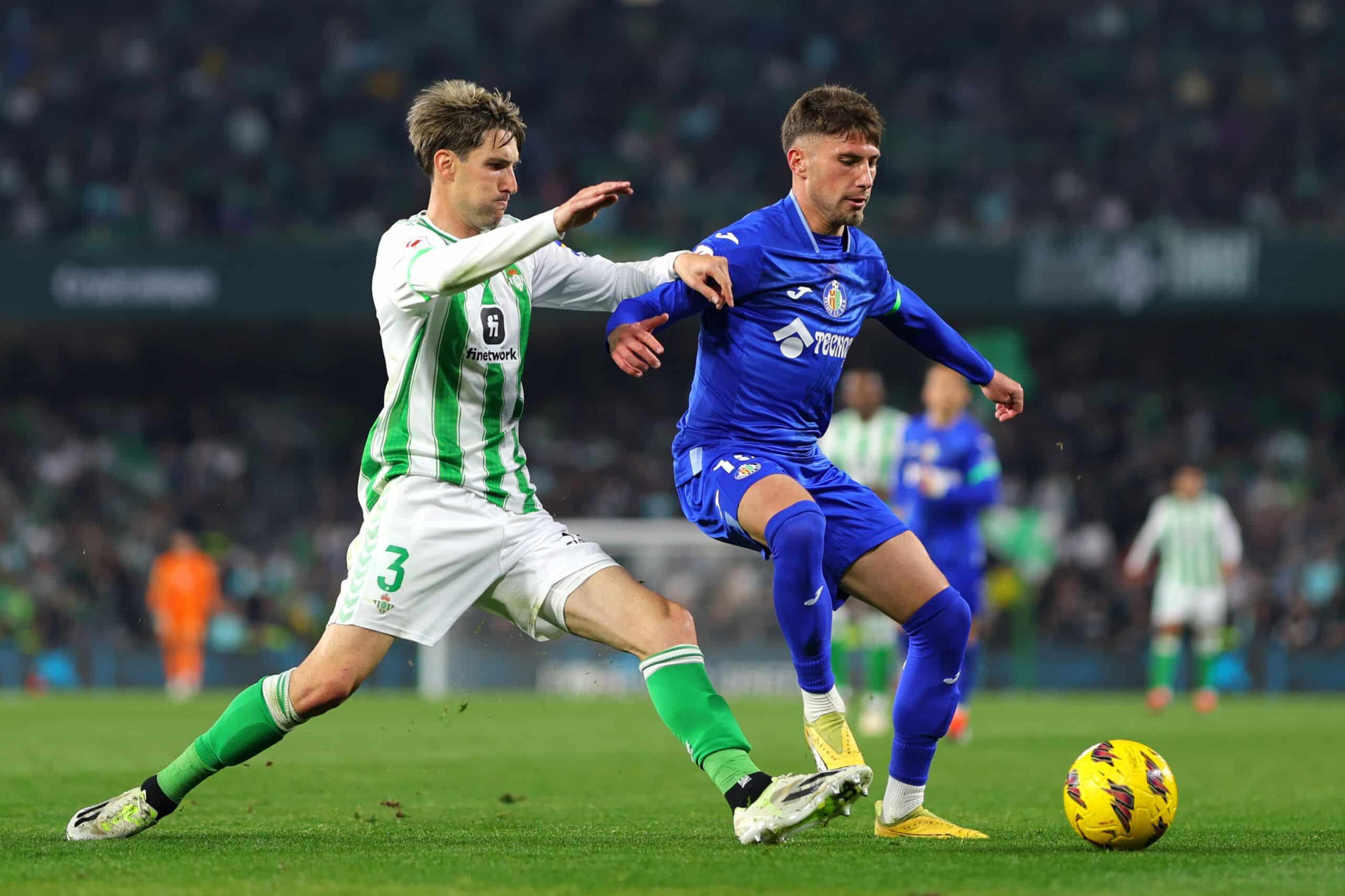 SEVILLE, SPAIN - FEBRUARY 04: Jose Angel Carmona of Getafe CF is challenged by Juan Miranda of Real Betis during the LaLiga EA Sports match between Real Betis and Getafe CF at Estadio Benito Villamarin on February 04, 2024 in Seville, Spain. (Photo by Fran Santiago/Getty Images)