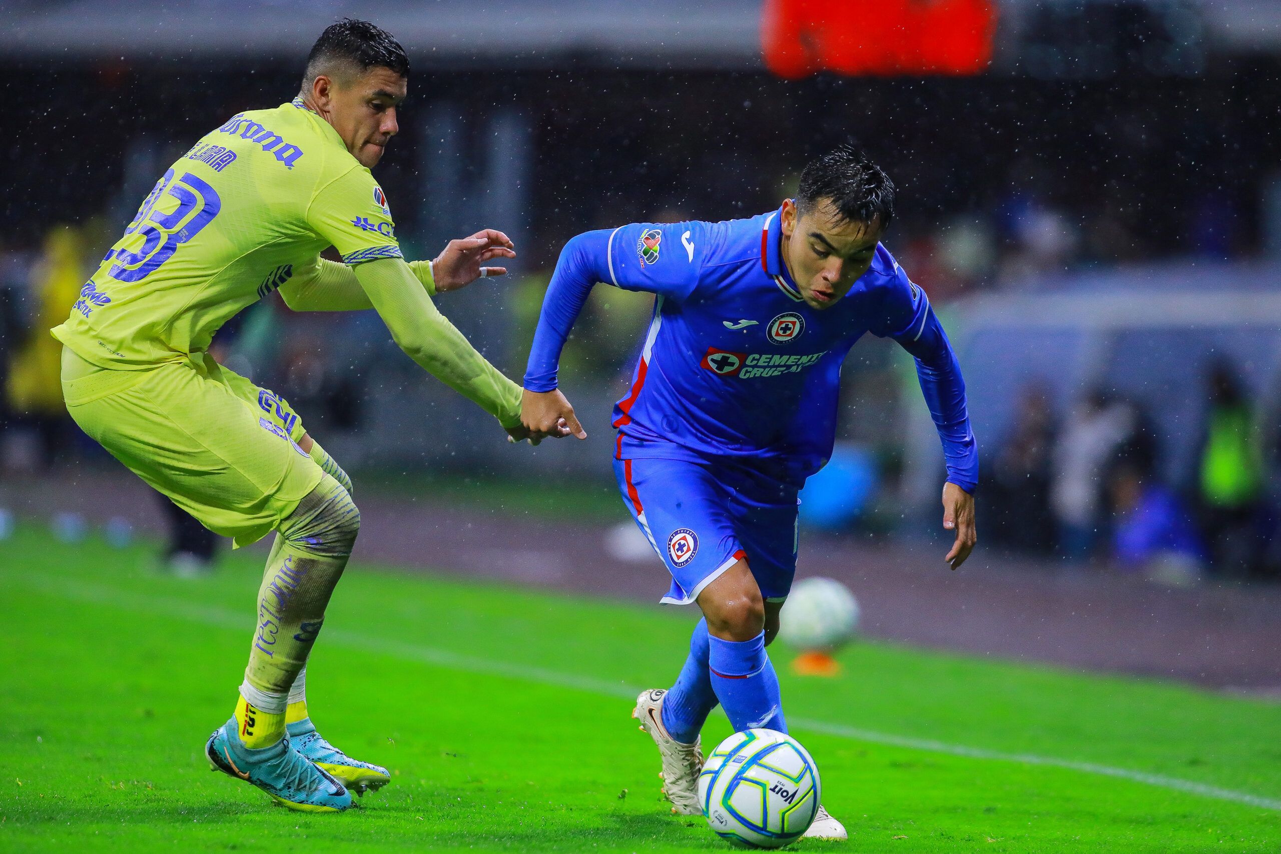 MEXICO CITY, MEXICO - AUGUST 20: Emilio Lara (L) of America battles for the ball against Carlos Rodríguez (R) of Cruz Azul during the 10th round match between America and Cruz Azul as part of the Torneo Apertura 2022 Liga MX at Azteca Stadium on August 20, 2022 in Mexico City, Mexico. (Photo by Manuel Velasquez/Getty Images)