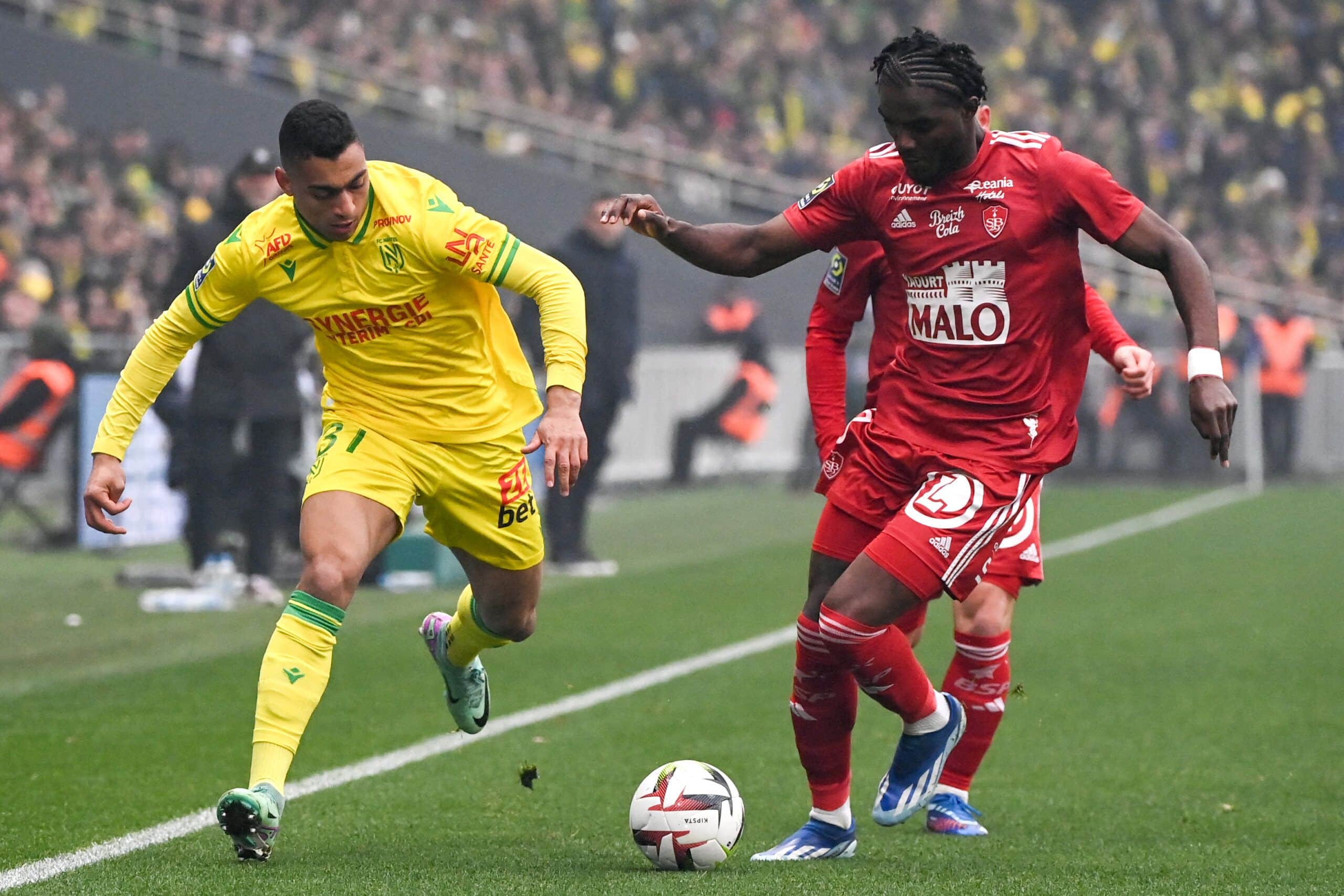 Nantes' Egyptian forward #31 Mostafa Mohamed (L) fights for the ball with Brest's French defender #03 Lilian Brassier (R) during the French L1 football match between FC Nantes and Stade Brestois 29 (Brest) at the Stade de la BeaujoireLouis Fonteneau in Nantes, western France on December 17, 2023. (Photo by Sebastien SALOM-GOMIS / AFP) (Photo by SEBASTIEN SALOM-GOMIS/AFP via Getty Images)