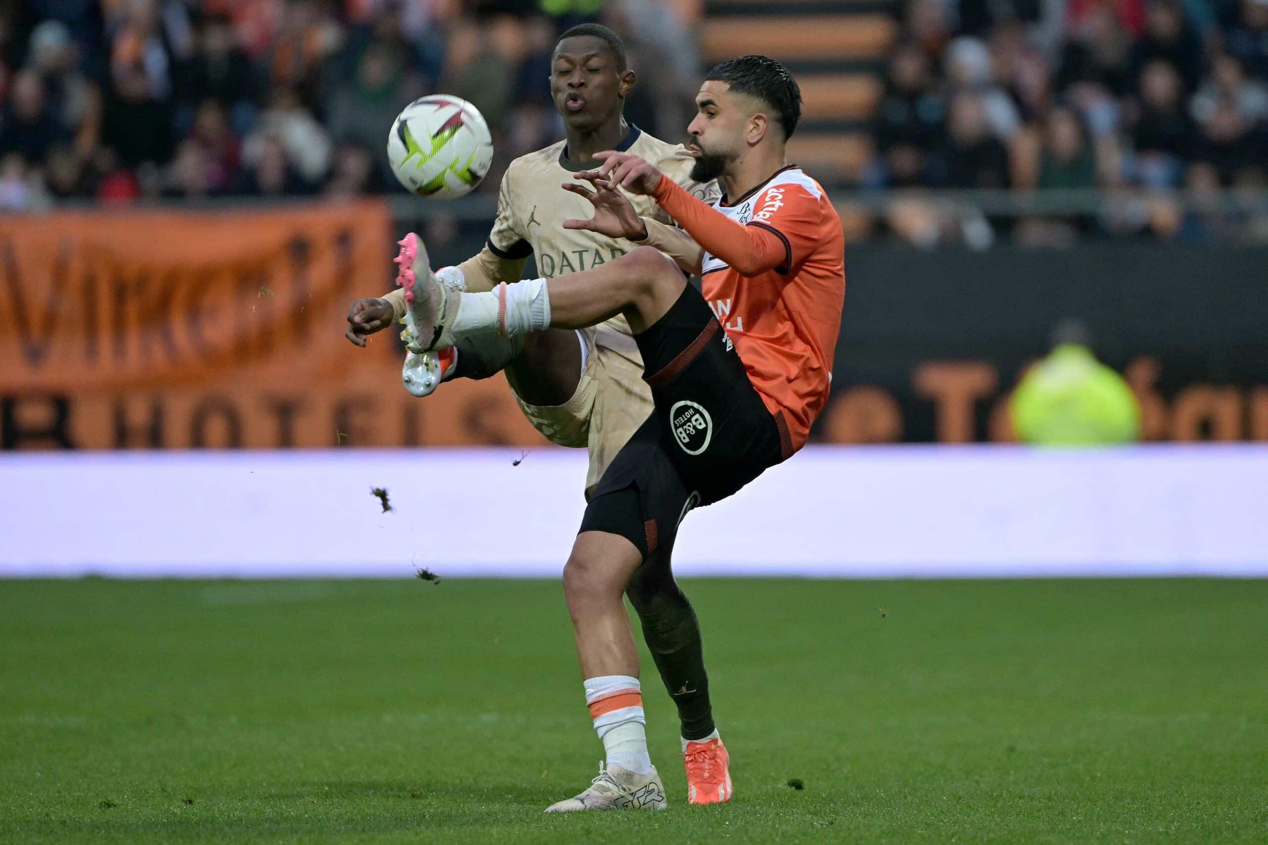 Lorient's Moroccan midfielder #06 Imran Louza (R) and Paris Saint-Germain's Portuguese defender #02 Nuno Mendes (L) fight for the ball during the French L1 football match between FC Lorient and Paris Saint-Germain (PSG) at the Stade du Moustoir in Lorient, western France, on April 24, 2024. (Photo by DAMIEN MEYER / AFP) (Photo by DAMIEN MEYER/AFP via Getty Images)