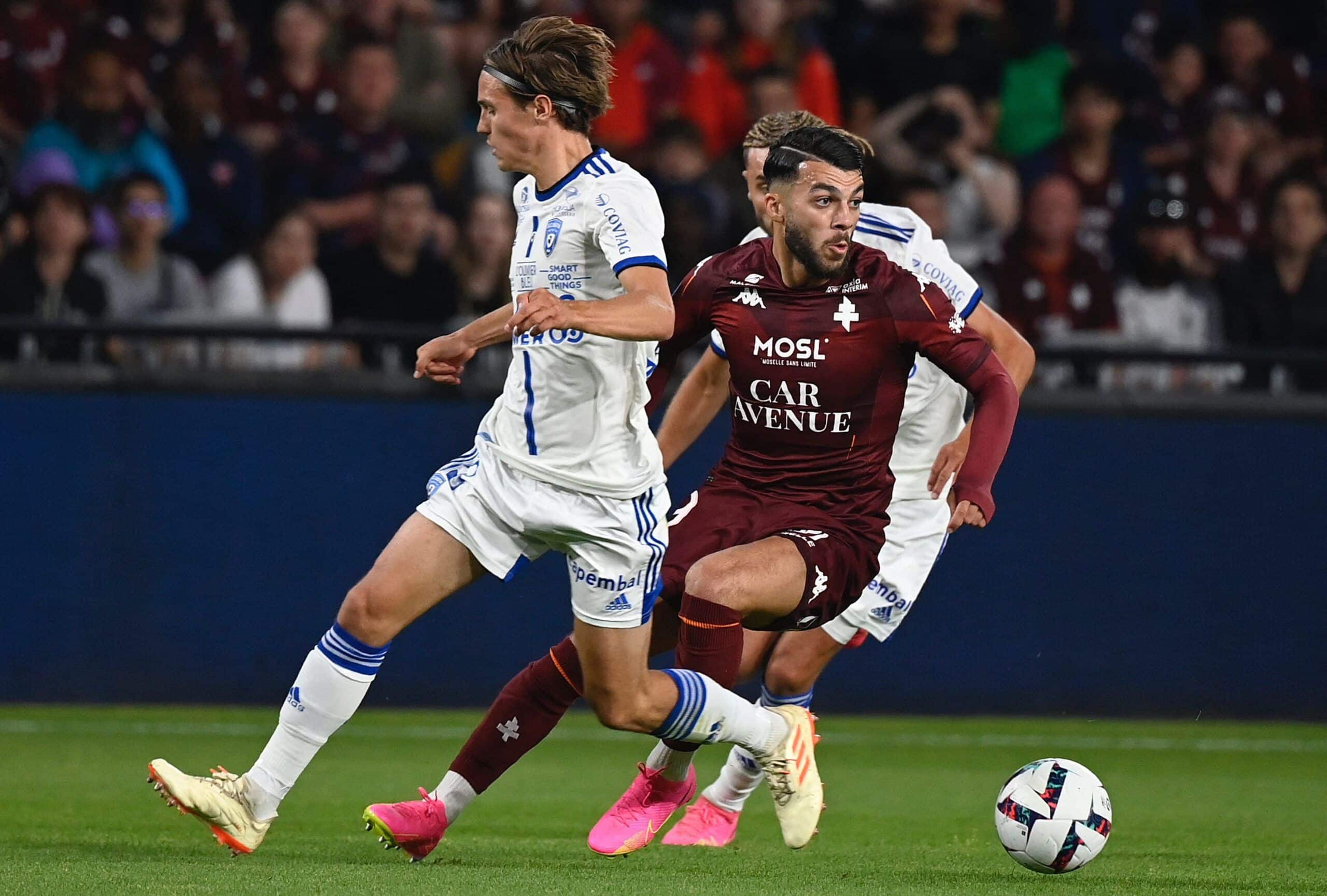 Bastia's French midfielder Tom Ducrocq (L) fights for the ball with Metz's Georgian forward Georges Mikautadze during the French L2 football match between FC Metz and SC Bastia at Stade Saint-Symphorien in Longeville-Les-Metz, northeastern France, on June 2, 2023. (Photo by Jean-Christophe Verhaegen / AFP) (Photo by JEAN-CHRISTOPHE VERHAEGEN/AFP via Getty Images)