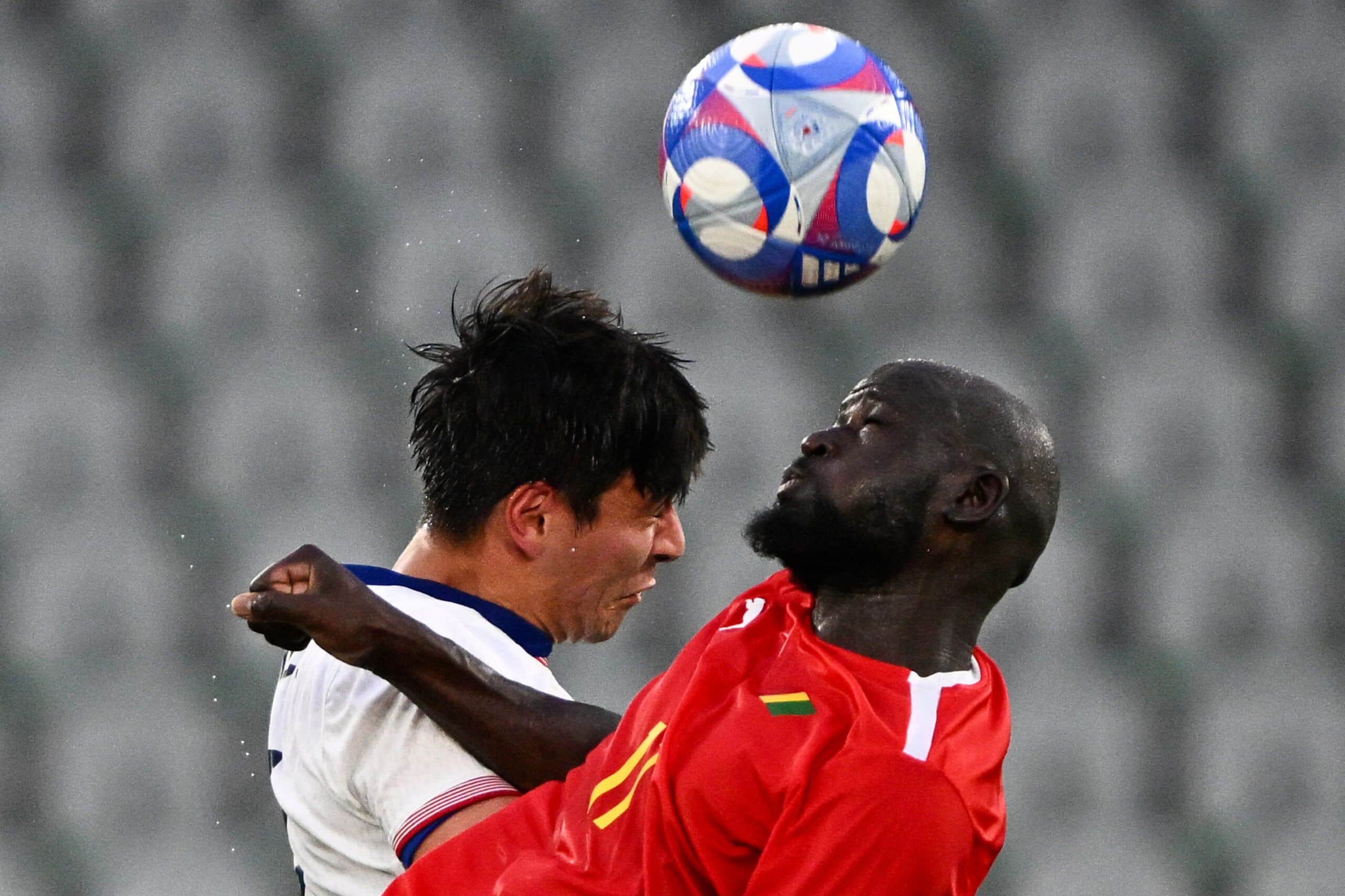 Guinea's forward #11 Ousmane Camara (R) fights for the ball with US' #21 midfielder Josh Atencio in the men's group A football match between USA and Guinea during the Paris 2024 Olympic Games, at Geoffroy Guichard stadium in Saint-Étienne, central France, on July 30, 2024. (Photo by ARNAUD FINISTRE / AFP) (Photo by ARNAUD FINISTRE/AFP via Getty Images)