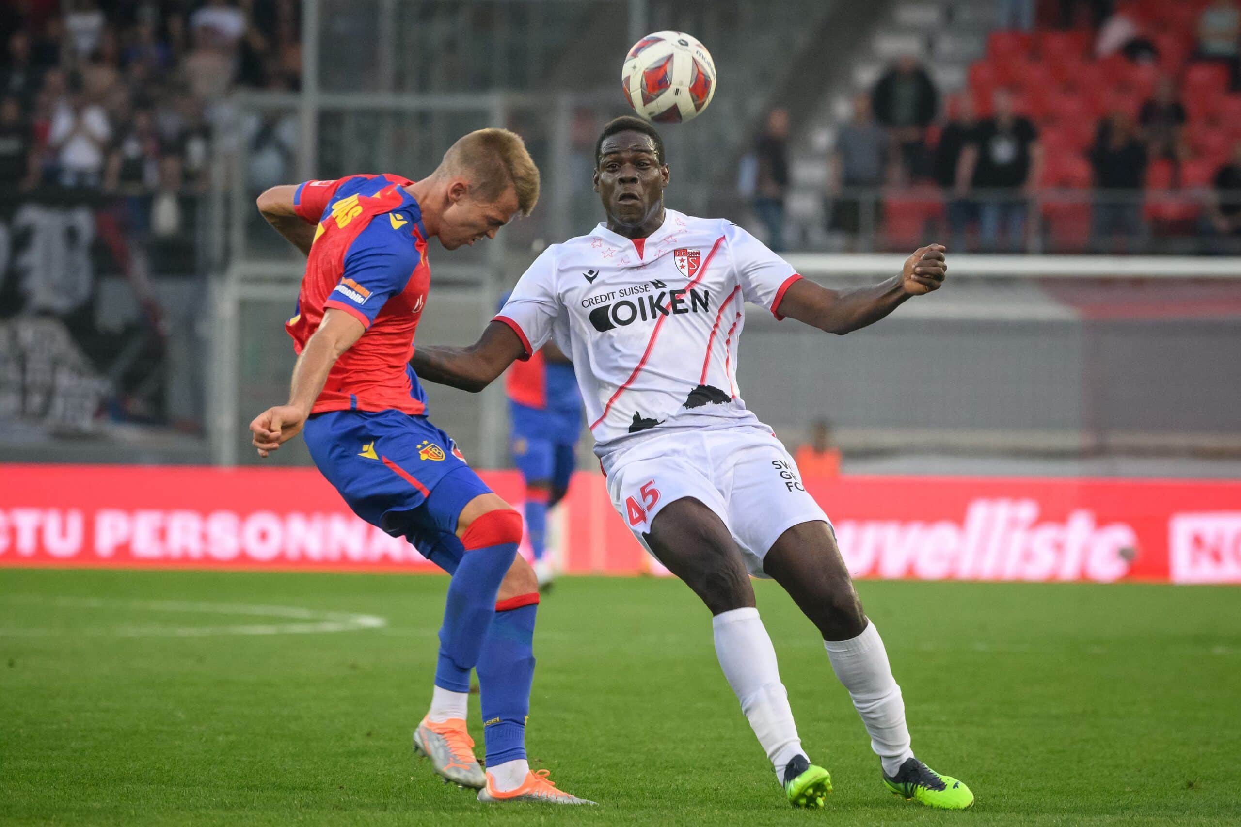 FC Sion's Italian forward Mario Balotelli (R) fights for the ball with FC Basel's Spanish defender Arnau Comas during their Swiss super league football match FC Sion against FC Basel at the Tourbillon stadium in Sion, on September 3, 2022. - Balotelli signed on August 31, 2022 a two-year contract with Swiss side FC Sion, the 11th club of his career. (Photo by Fabrice COFFRINI / AFP) (Photo by FABRICE COFFRINI/AFP via Getty Images)