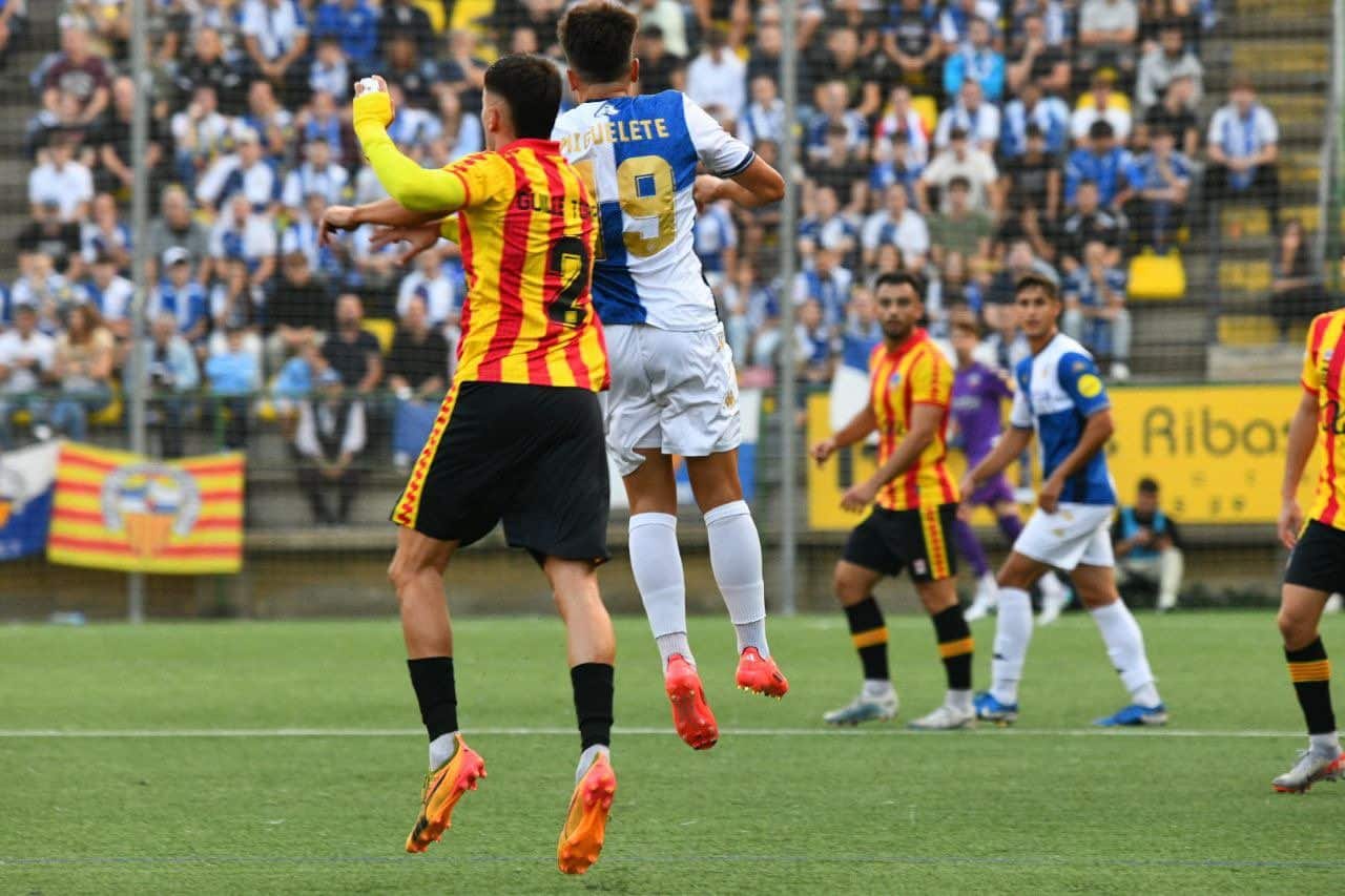 Los futbolistas Guille Torres y Miguelete, de los distintos equipos, luchando por conseguir dominar el esférico en el terreno de juego. Fuente: @CESabadell.