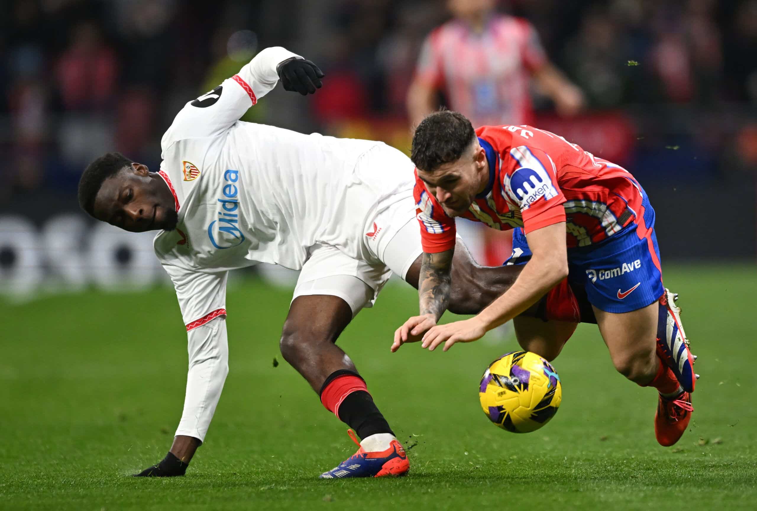 MADRID, SPAIN - DECEMBER 08: Javi Galan of Atletico de Madrid (R) is fouled by Lucien Agoume of Sevilla FC during the LaLiga match between Atletico de Madrid and Sevilla FC at Riyadh Air Metropolitano on December 08, 2024 in Madrid, Spain. (Photo by Denis Doyle/Getty Images)