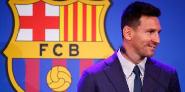 Leo Messi, y el escudo del Barcelona.